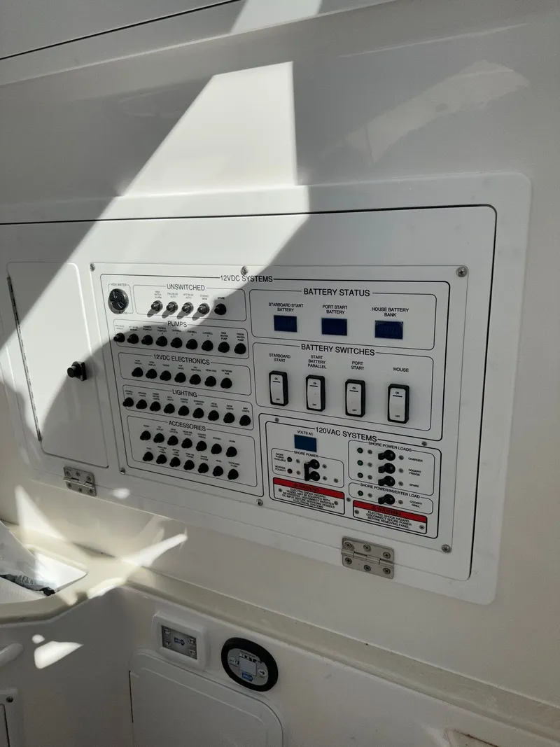 Slide: The Image of Electrical control panel on a 2023 Edgewater 285CC boat, featuring battery status and switches. - 21
