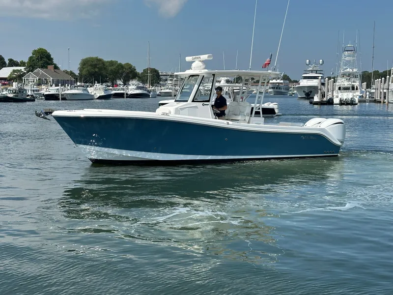 Slide: The Image of 2023 Edgewater 285CC boat cruising in a marina with multiple yachts in the background. - 9