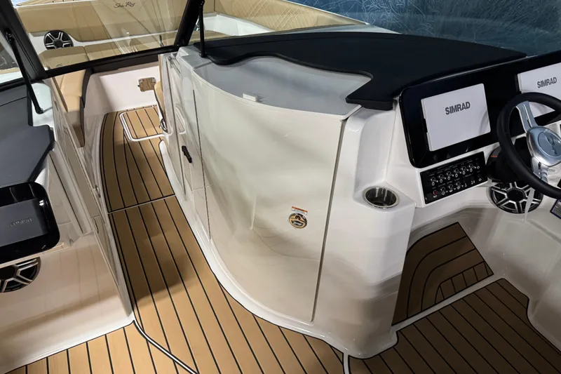 Slide: The Image of 2026 Sea Ray SDX 270 Surf boat interior with Simrad electronics and teak flooring. - 16