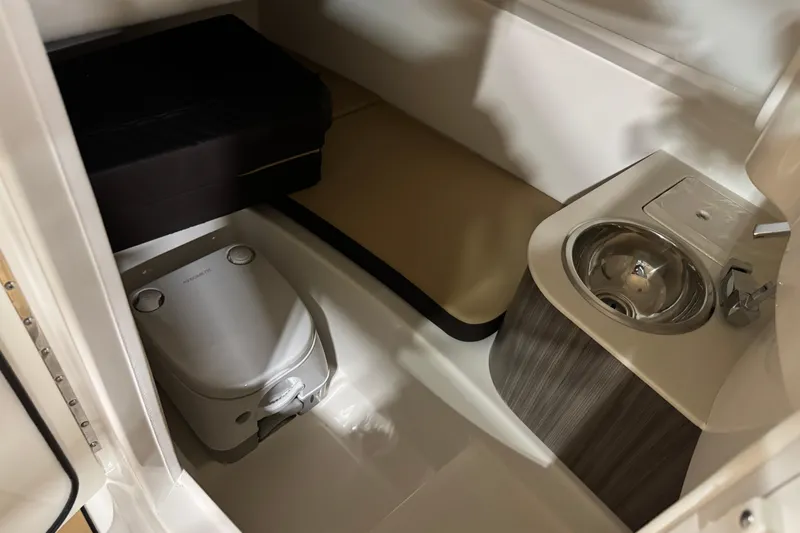 Slide: The Image of 2026 Sea Ray SDX 270 Surf boat interior with compact toilet and sink. - 17