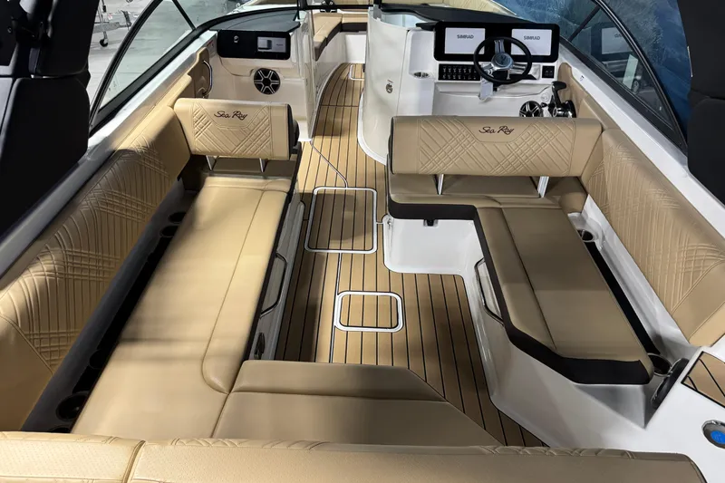 Slide: The Image of 2026 Sea Ray SDX 270 Surf boat interior with tan seating and wood-style flooring. - 8