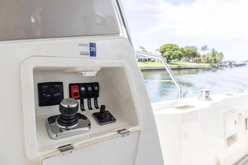Slide: The Image of Control panel on a 2015 Prestige 550 Flybridge yacht, overlooking a serene waterfront. - 11
