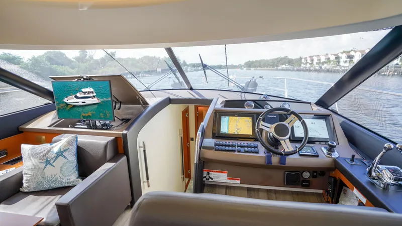 Slide: The Image of Interior view of 2015 Prestige 550 Flybridge yacht cockpit with navigation screens and steering wheel. - 20