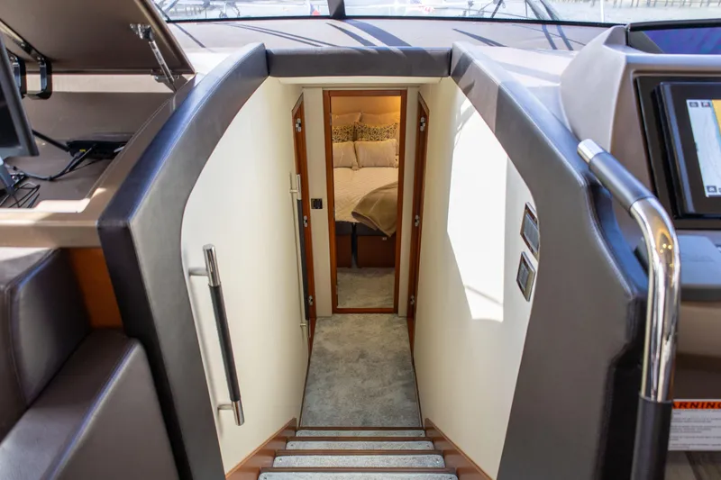 Slide: The Image of Interior view of 2015 Prestige 550 Flybridge yacht, showing stairs leading to a cozy bedroom. - 22