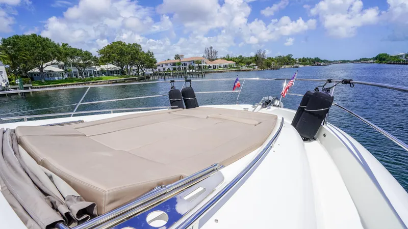 Slide: The Image of 2015 Prestige 550 Flybridge yacht on serene waterway, featuring spacious sun deck. - 44