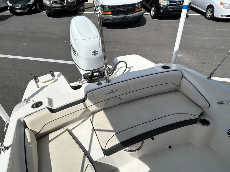 Slide: The Image of 2021 Stingray 191 DC boat interior with Suzuki outboard motor in parking lot. - 11