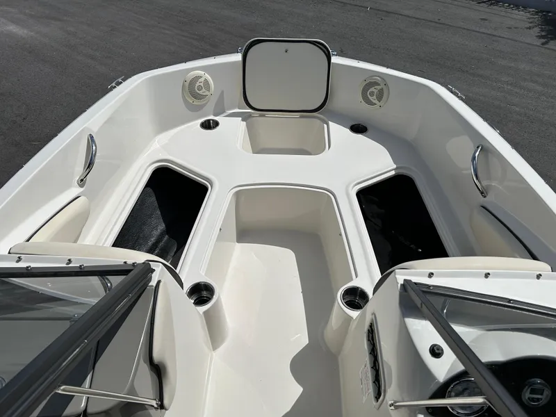 Slide: The Image of 2021 Stingray 191 DC boat interior with open storage compartments and cup holders. - 12
