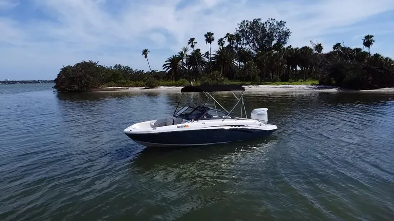 Slide: The Image of 2021 Stingray 191 DC boat on calm water near a tropical island. - 14