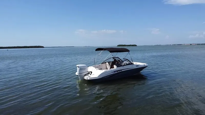 Slide: The Image of 2021 Stingray 191 DC boat on calm water under clear blue sky. - 15