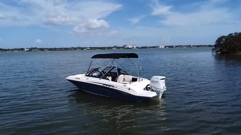 Slide: The Image of 2021 Stingray 191 DC boat on calm water under a blue sky. - 16