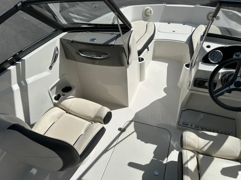 Slide: The Image of 2021 Stingray 191 DC boat interior with seating, steering wheel, and cup holders. - 9