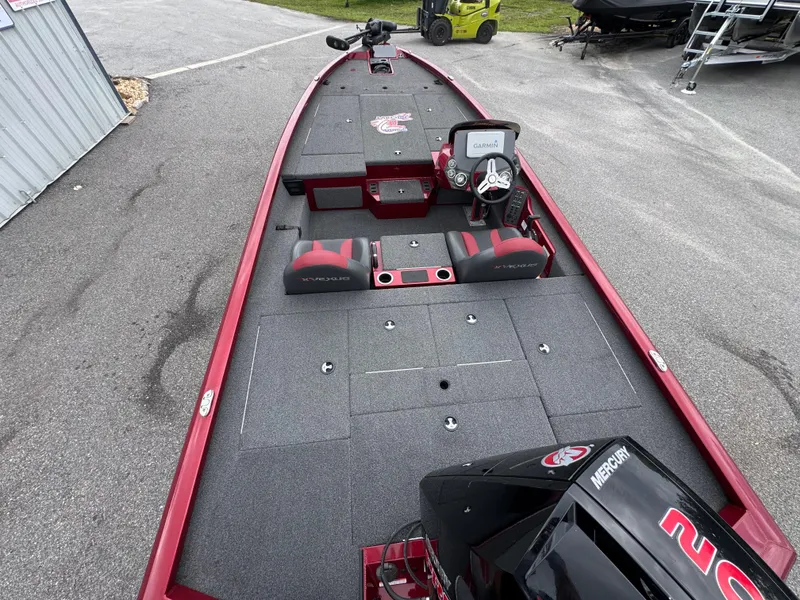 Slide: The Image of 2022 Vexus AVX2080 boat with red accents and Mercury engine, parked on pavement. - 11