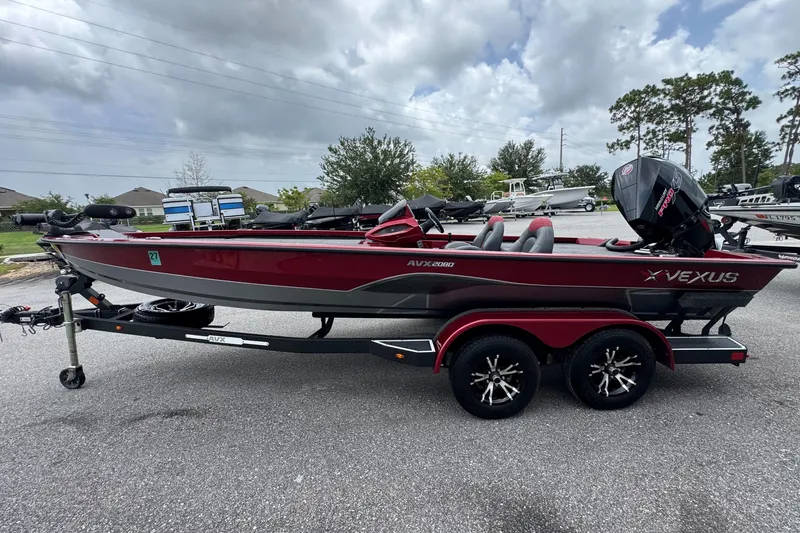 Slide: The Image of 2022 Vexus AVX2080 boat on trailer, red and black design, parked outdoors. - 4
