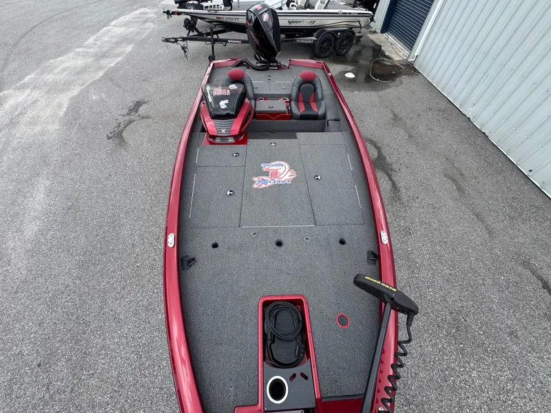 Slide: The Image of 2022 Vexus AVX2080 boat with red accents, parked on pavement near a building. - 8