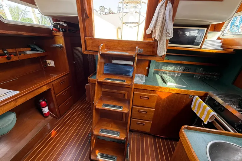 Slide: The Image of Interior of 1979 Gulfstar 43 MK II sailboat with wooden cabinetry and compact kitchen area. - 21