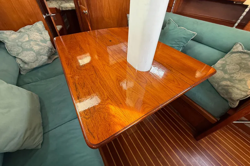 Slide: The Image of Interior of 1979 Gulfstar 43 MK II yacht with polished wooden table and teal cushions. - 24