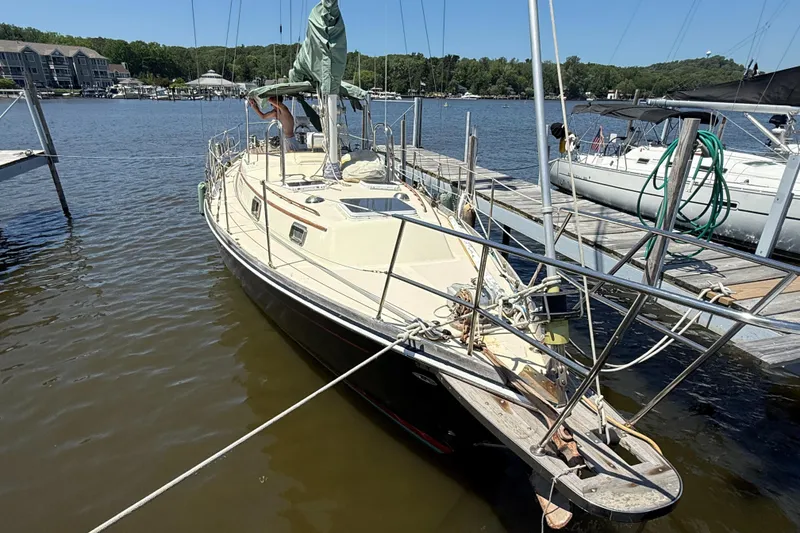Slide: The Image of 1979 Gulfstar 43 MK II sailboat docked at a marina, surrounded by calm water. - 3