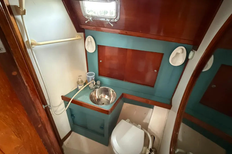 Slide: The Image of 1979 Gulfstar 43 MK II yacht bathroom with sink, toilet, and wooden cabinetry. - 30