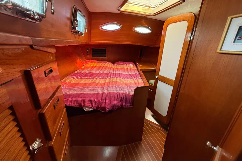 Slide: The Image of Cozy cabin interior of 1979 Gulfstar 43 MK II sailboat with wood finish and striped bedding. - 38