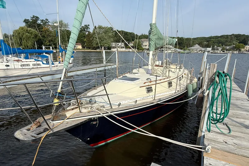 Slide: The Image of 1979 Gulfstar 43 MK II sailboat docked at a marina, surrounded by calm water. - 4