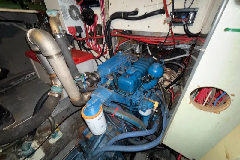 Slide: The Image of Engine compartment of a 1979 Gulfstar 43 MK II sailboat, featuring blue machinery and wiring. - 43