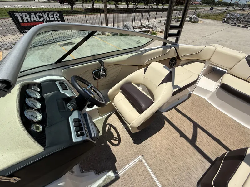 Slide: The Image of 2018 Regal 22 FasDeck boat interior with beige seating and dashboard controls. - 15