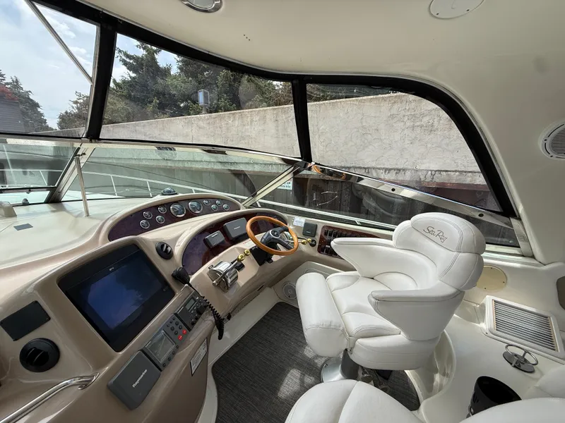 Slide: The Image of Helm of 2000 Sea Ray 460 Sundancer with white leather seat and modern controls. - 10
