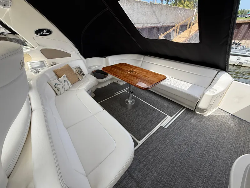 Slide: The Image of Luxurious interior of 2000 Sea Ray 460 Sundancer yacht with elegant seating and wooden table. - 11
