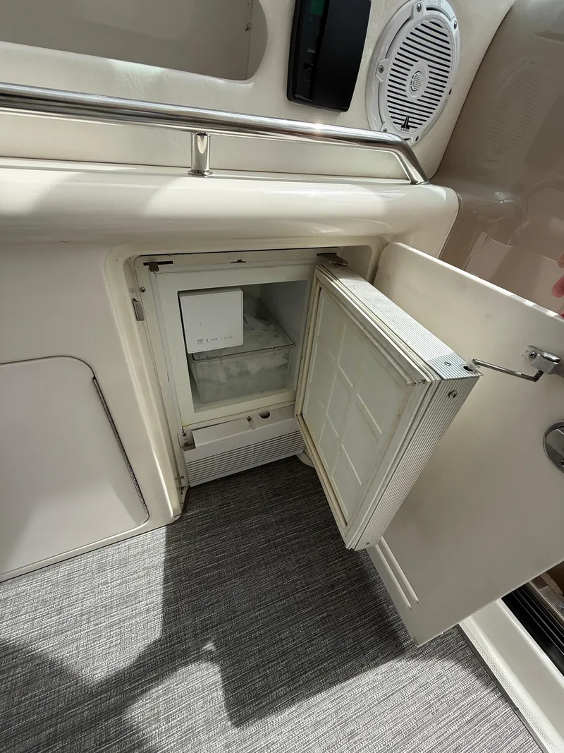 Slide: The Image of Open mini fridge on 2000 Sea Ray 460 Sundancer yacht, showcasing interior storage space. - 13