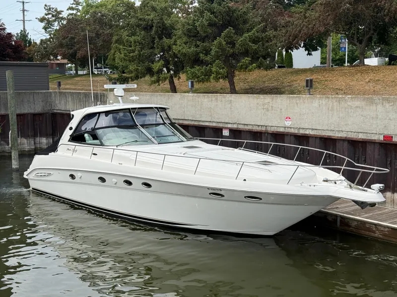 Slide: The Image of 2000 Sea Ray 460 Sundancer yacht docked in a marina, surrounded by trees. - 2