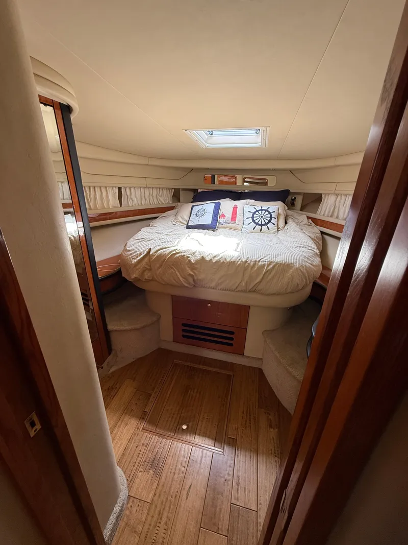 Slide: The Image of Cozy cabin interior of 2000 Sea Ray 460 Sundancer with nautical-themed bedding. - 26