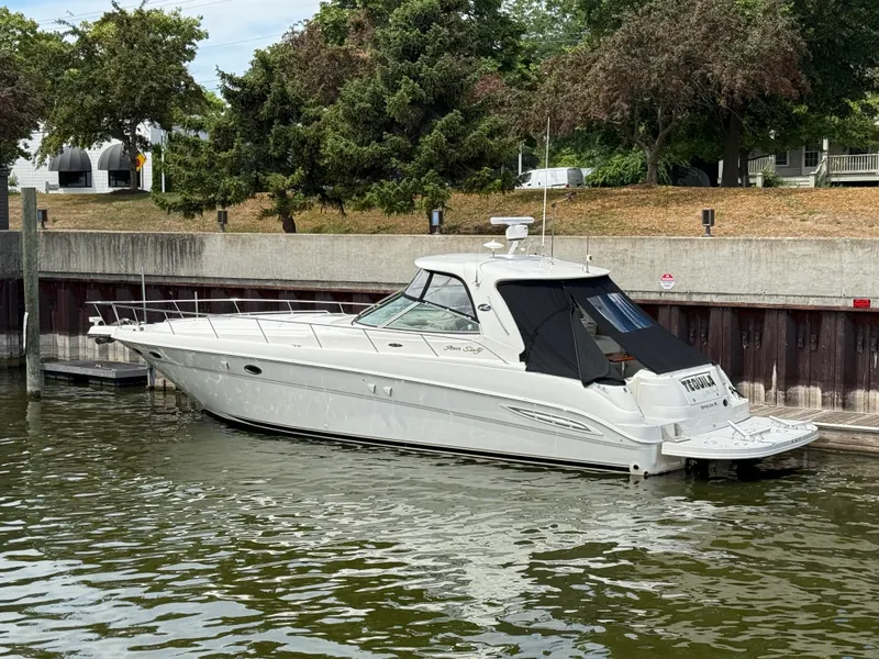 Slide: The Image of 2000 Sea Ray 460 Sundancer yacht docked in a marina, surrounded by trees. - 4