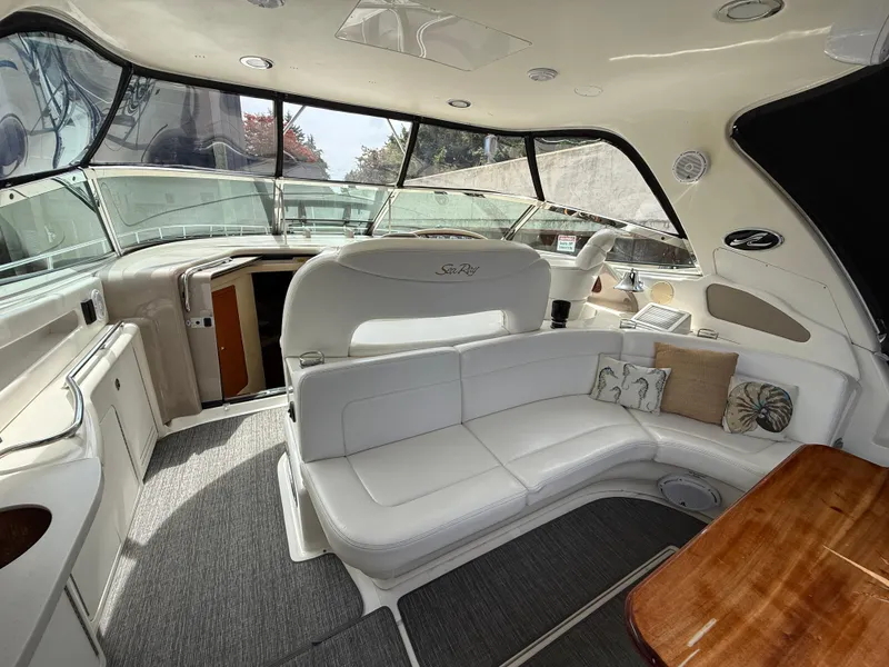 Slide: The Image of Interior of 2000 Sea Ray 460 Sundancer yacht with white seating and wooden table. - 6