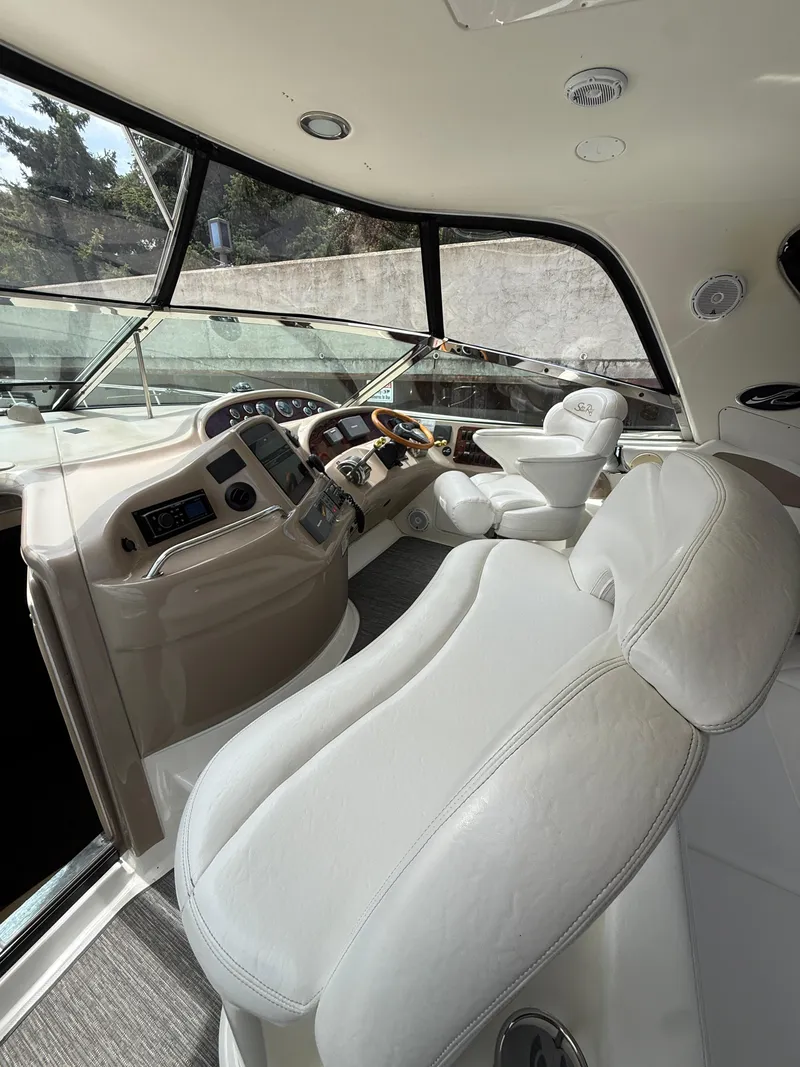 Slide: The Image of Interior of 2000 Sea Ray 460 Sundancer yacht with luxurious seating and control panel. - 9