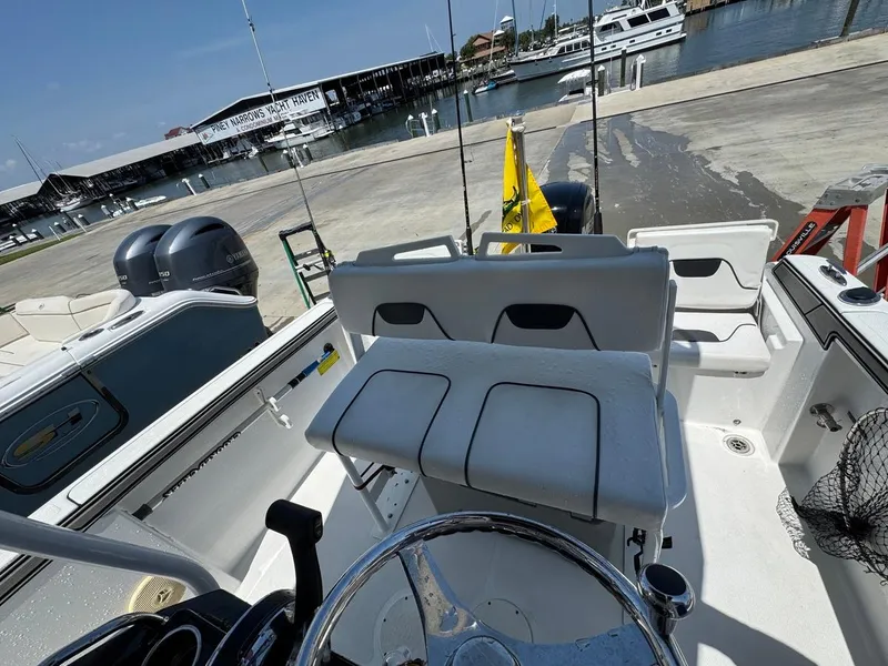 Slide: The Image of 2020 Wellcraft 182 Fisherman boat interior at marina, featuring dual engines and seating. - 11