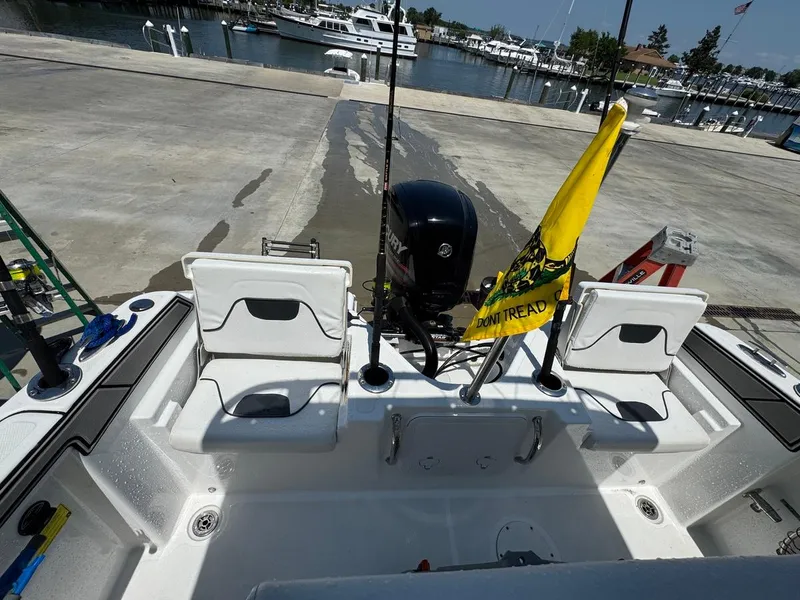 Slide: The Image of 2020 Wellcraft 182 Fisherman boat at dock, featuring outboard motor and "Don't Tread" flag. - 14