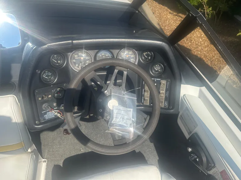 Slide: The Image of 1990 MasterCraft Prostar190 dashboard with steering wheel and gauges in sunlight. - 10