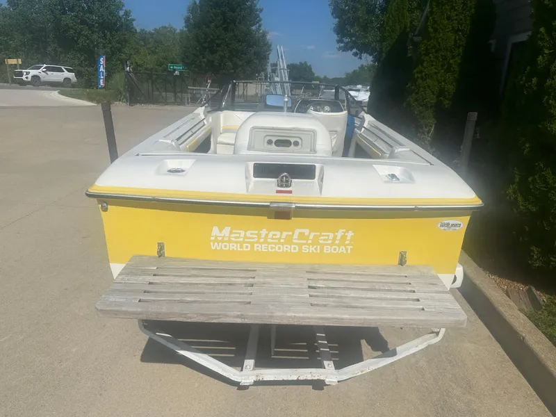 Slide: The Image of 1990 MasterCraft Prostar190 ski boat, yellow and white, parked on a trailer. - 2
