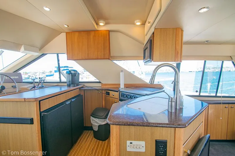 Slide: The Image of Interior of 2002 Bayliner 3988 Command Bridge Motoryacht kitchen with modern amenities and ocean view. - 14