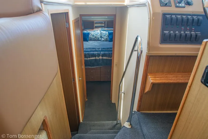 Slide: The Image of Interior view of 2002 Bayliner 3988 Command Bridge Motoryacht, featuring stairs and a cozy bedroom. - 21