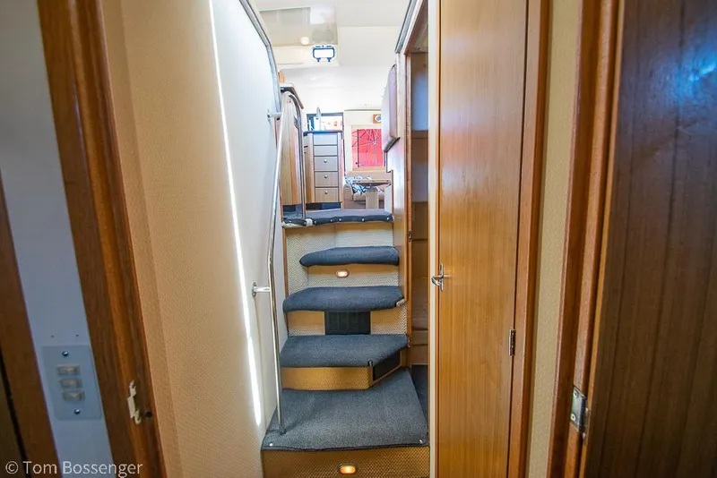Slide: The Image of Interior stairs of 2002 Bayliner 3988 Command Bridge Motoryacht, featuring wooden paneling and carpeted steps. - 27