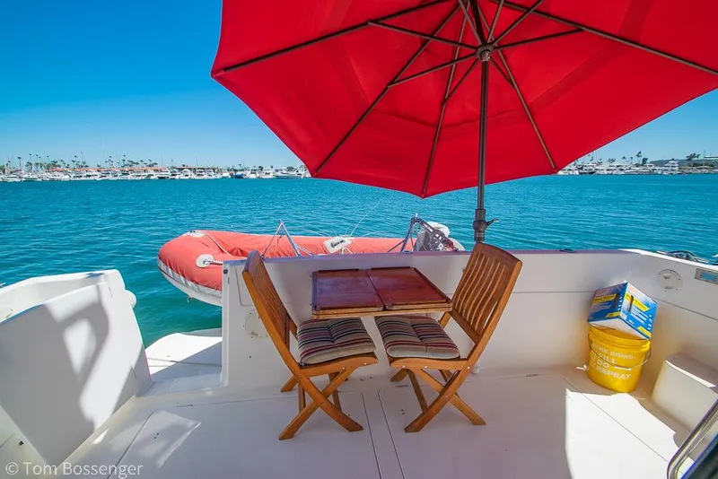 Slide: The Image of 2002 Bayliner 3988 Command Bridge Motoryacht deck with red umbrella and ocean view. - 36