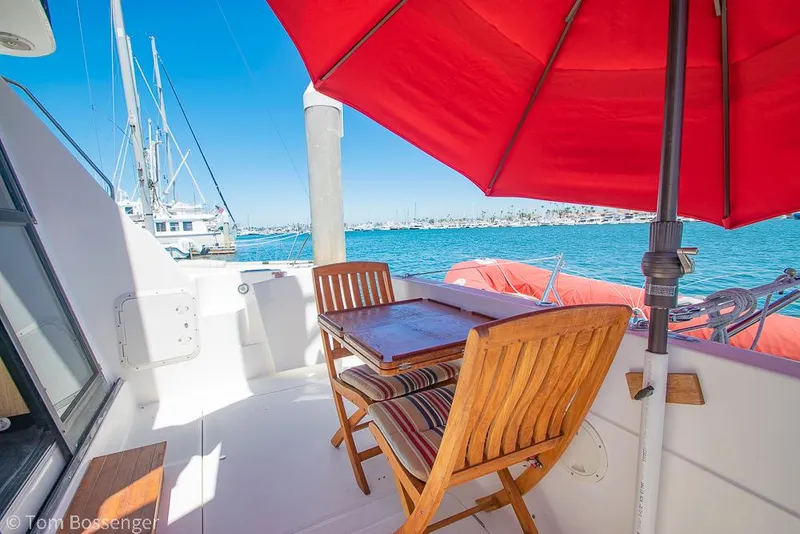 Slide: The Image of Bayliner 3988 Command Bridge Motoryacht 2002 deck with table, chairs, and red umbrella. - 37