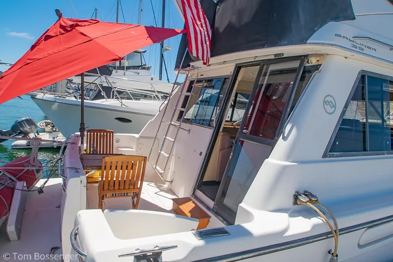 Slide: The Image of 2002 Bayliner 3988 Command Bridge Motoryacht with red umbrella and wooden chairs on deck. - 5