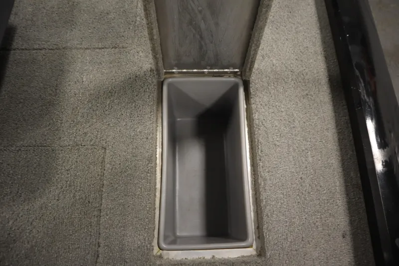 Slide: The Image of Storage compartment in 2012 Tracker 190 TX Pro Team boat, featuring gray carpeted interior. - 39