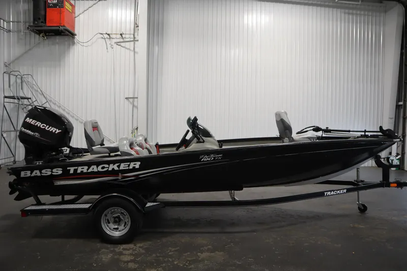 Slide: The Image of 2012 Tracker 190 TX Pro Team bass boat with Mercury engine in a garage setting. - 5