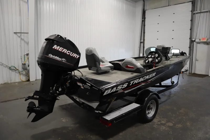 Slide: The Image of 2012 Tracker 190 TX Pro Team bass boat with Mercury OptiMax engine in a garage. - 6