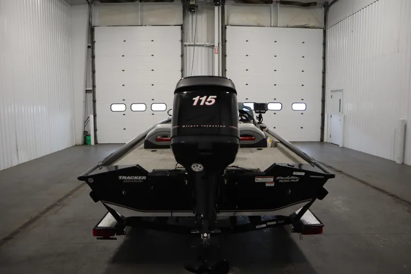 Slide: The Image of 2012 Tracker 190 TX Pro Team boat in a garage, rear view with motor. - 7