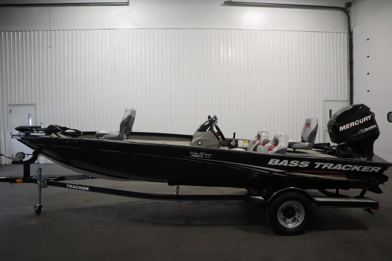Slide: The Image of 2012 Tracker 190 TX Pro Team bass boat with Mercury engine in a garage. - 9
