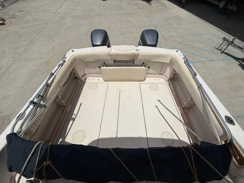 Slide: The Image of 1997 Grady-White F-26 Tigercat boat interior with dual engines, docked on concrete. - 13